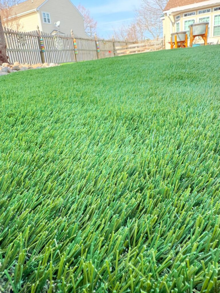 Close-up view of artificial grass installed across a residential backyard