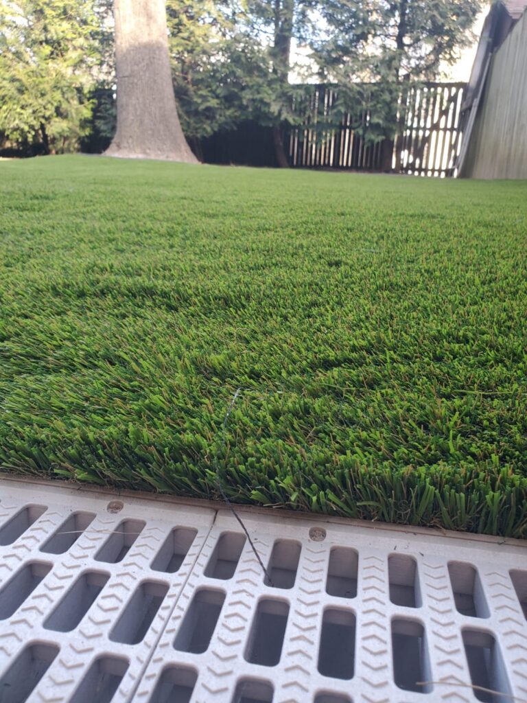 Close-up of artificial turf with a finished edge in a residential backyard